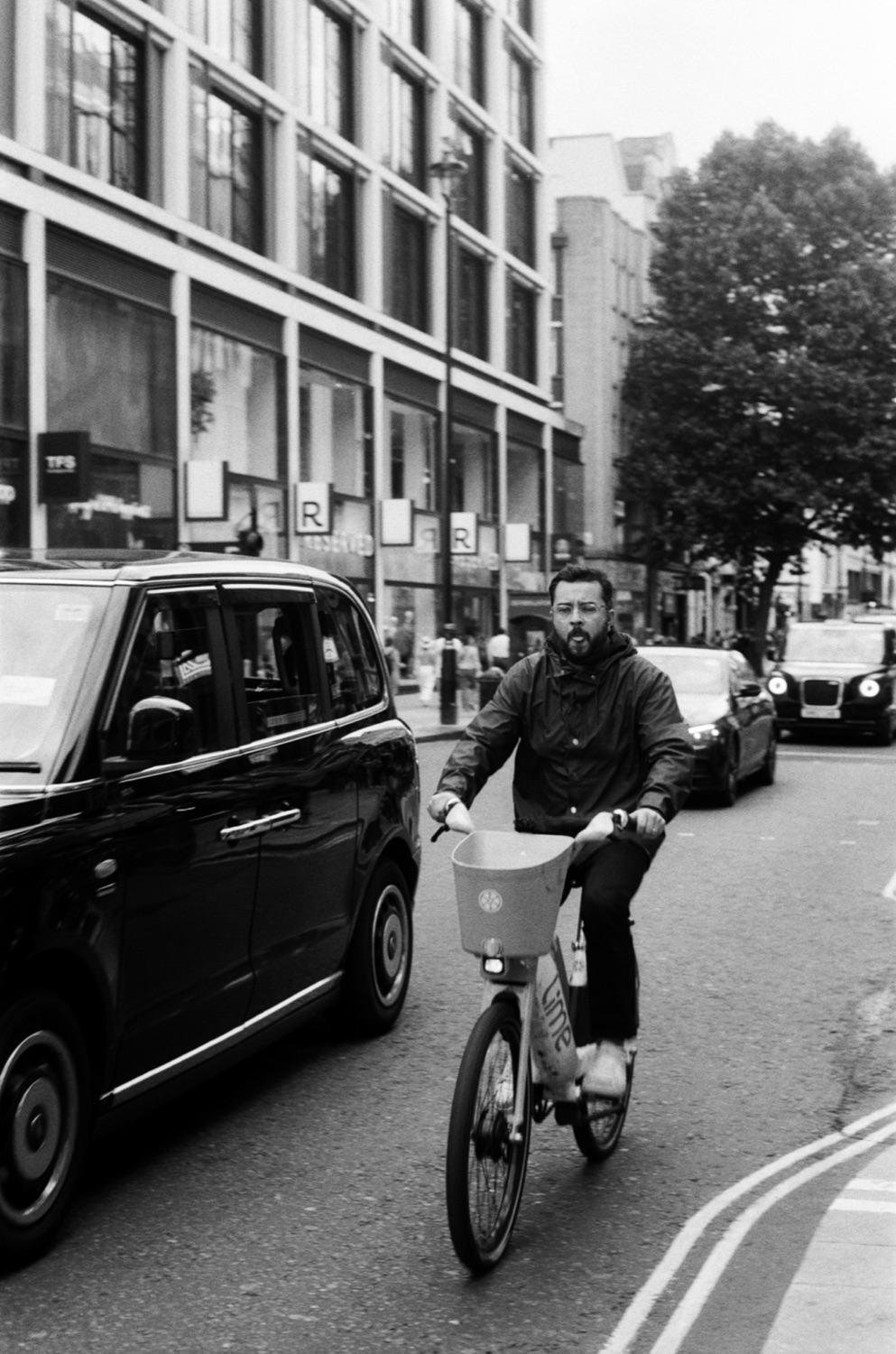 Cyclist on London street, black and white