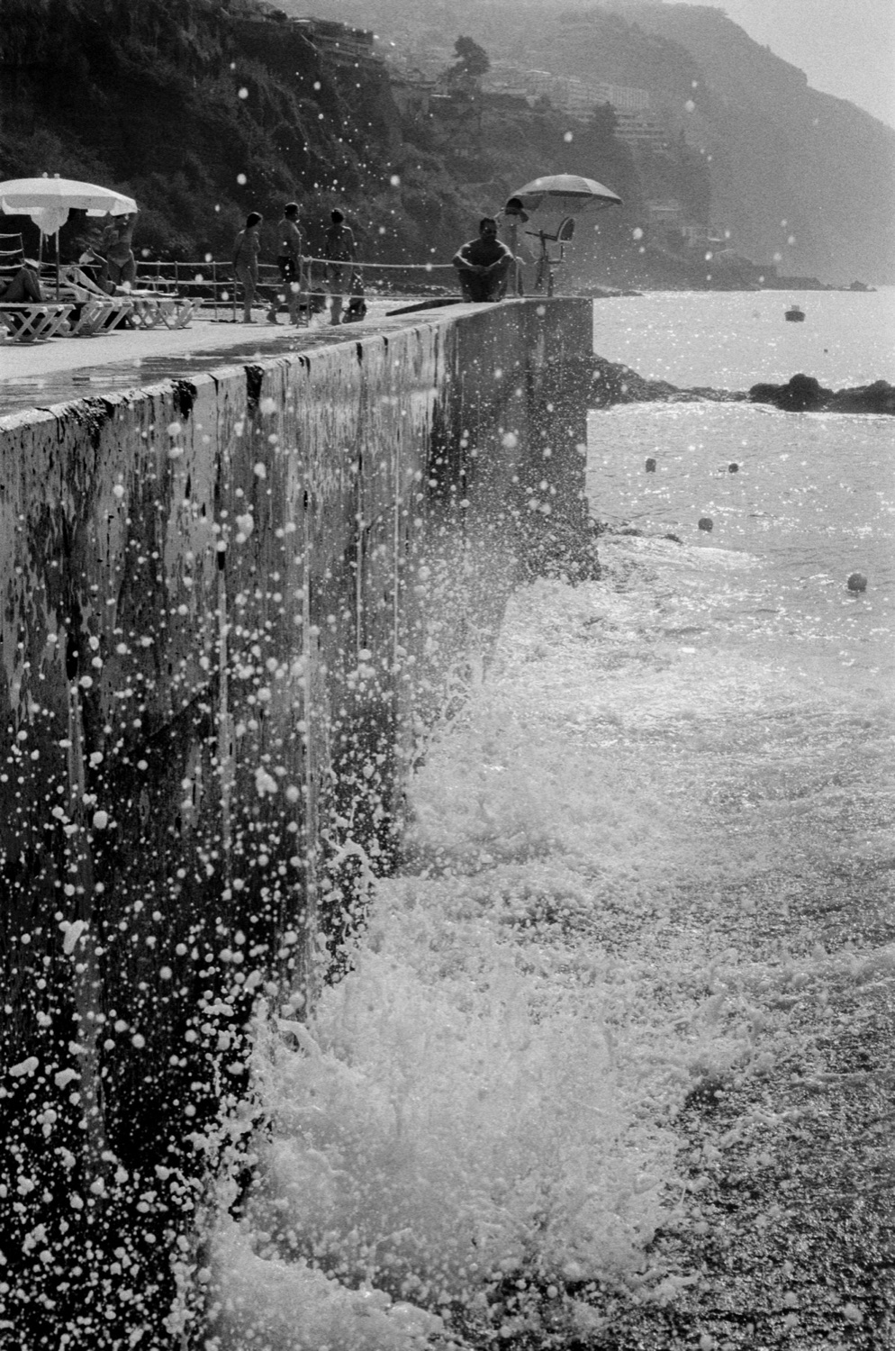 Waves crashing seawall, black and white