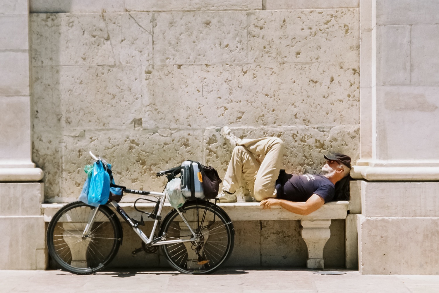 Man resting by bicycle, plaza